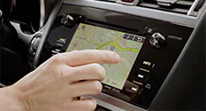 A person's finger touching the Subaru navigation screen.