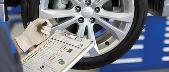 A Subaru service technician reviewing a multipoint inspection form.